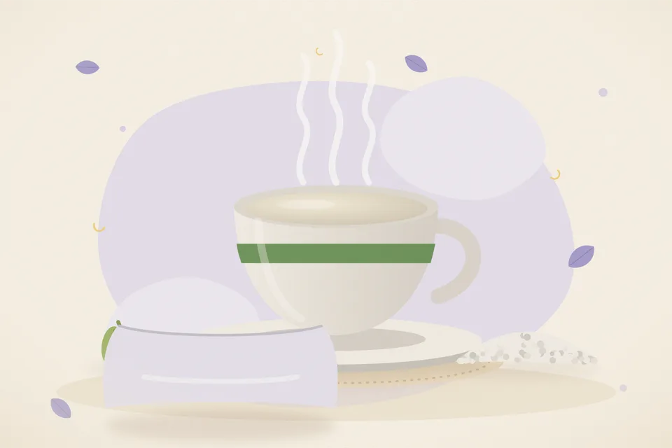 A cup of warm milk, two green cardamom pods, and a few clear mishri crystals on a brass kitchen plate.