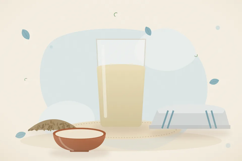Ajwain seeds beside a bowl of hot water and a loose cotton cloth on a table, the bowl away from the edge.