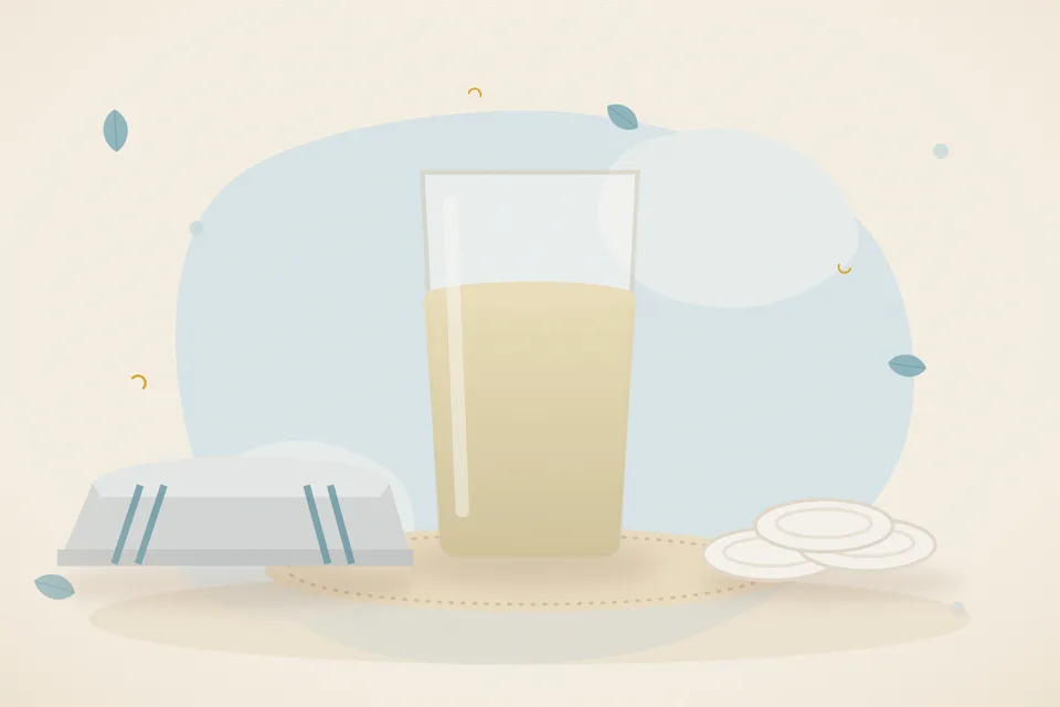 A brass cup of cool water on a wooden board next to a folded cotton towel