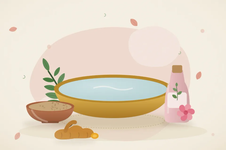 Neem leaves in a basin of water, a bowl of multani mitti clay, a bottle of rose water and turmeric on a rose-pink background