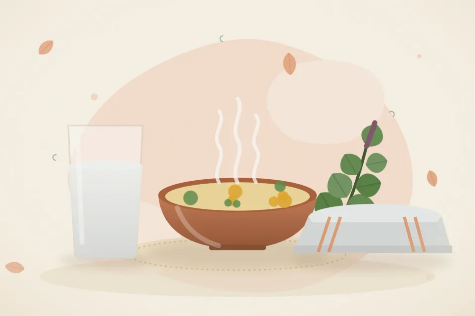 Glass of water, a bowl of thin khichdi, a folded damp cloth and a sprig of tulsi on a soft peach background