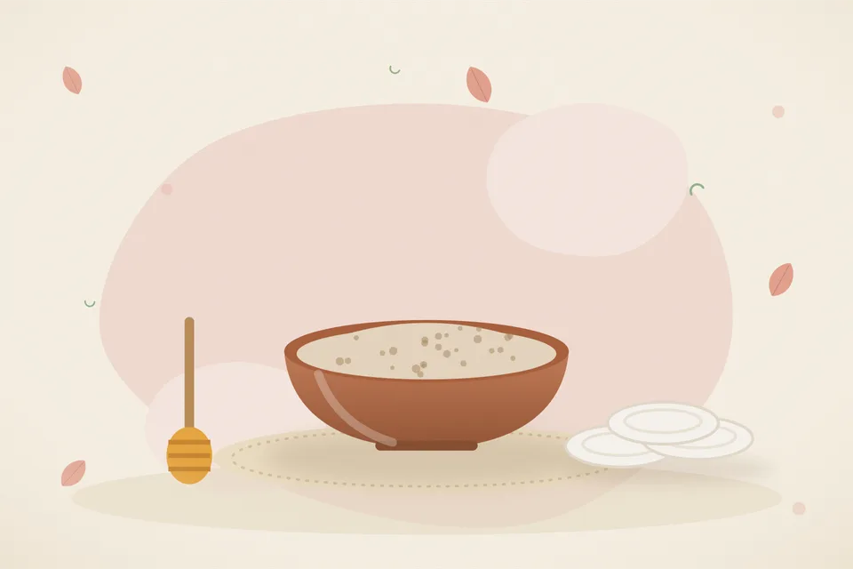 Kitchen still life of powdered oats, a jug of milk, and a spoon of honey on a linen cloth, with no people and no text.