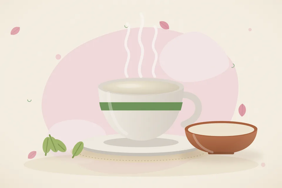 A small brass bowl of shatavari powder beside a cup of warm milk and two green cardamom pods on a stone kitchen counter.