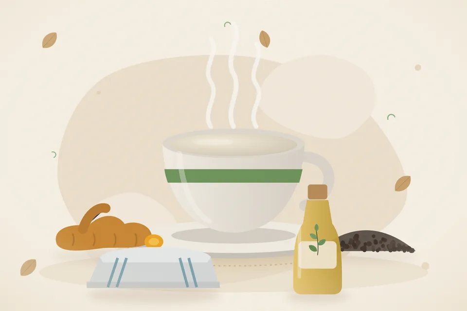 A brass cup of warm milk, a pinch of turmeric and a few black peppercorns on a wooden board